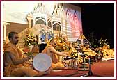 Saints sing and play musical instruments during the kirtan aradhana