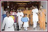 Balaks form a human train and escort Swamishri to the mandir murtis