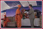 Mayor Hayes presenting a plaque to Pujya Anirdesh Swami commemorating August 20th as 