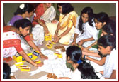 Mahila Mandal preparing beautiful artwork for Swamishri evening walk
