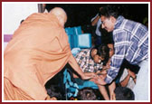 Swamishri blessing a physically challenged balak during  his evening walk 