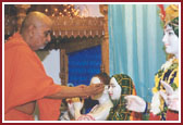 Swamishri performing idol installation of Radha Krishna