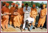 Dr. K. C. Patel breaks the sanctified coconut concluding the rituals