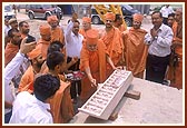 Swamishri first performs pujan of the sculpted stone to be placed by the crane