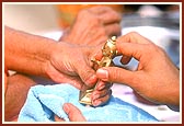 Swamishri ceremoniously bathes Shri Harikrishna Maharaj in panchamrut during the rituals