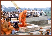 As part of the rituals Swamishri sprinkles water and panchamrut on the first stone