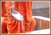 As part of the rituals Swamishri sprinkles water and panchamrut on the first stone