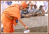 Swamishri pours cement to establish the first stone