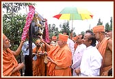 Declared by the local Municipalty, Swamishri unveils and offers pujan to the signboard declaring 'Swaminarayan Marg'