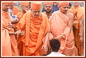 During his visit to the proposed land for a mandir Swamishri blesses an employee and his children who look after the proposed land for a new mandir