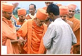 During his visit to the proposed land for a mandir Swamishri blesses an employee and his children who look after the proposed land for a new mandir