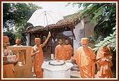 Swamishri circumambulating the shrine in front of Nishkuland Swami's Ordi (room)