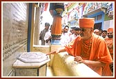 Swamishri touches the charnarvind installed in the mandir pradakshina