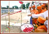 Swamishri and dignitaries sprinkle holy water into the adjoining Ahalya Sarovar