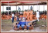 Swamishri arrives and therafter steps onto a raft