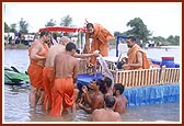 Swamishri blesses the sadhus who had worked for days in the water to make the lotus-shaped stage with an abhishek of water