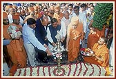 Swamishri and guests light the inaugural lamp